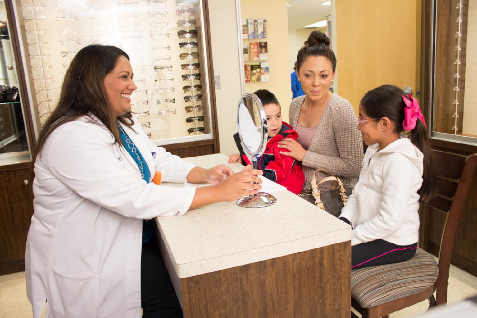 Children checking checking out glasses with provider